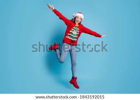 Photo portrait of funky girl jumping up making plane with hands laughing isolated on pastel light blue colored background