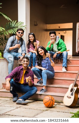 Asian Indian group of college students having tea of coffee together in break in campus premises outdoors. having chit chat Royalty-Free Stock Photo #1843231666