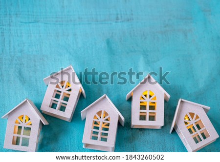 turquoise wood background with wooden houses with light and writing space