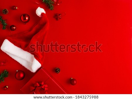 2020 New Year Christmas presents Santa hat with gifts and Christmas decorations on a red paper background copy space Top view with copy space.