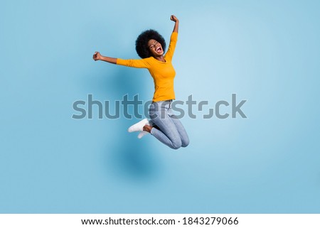 Photo portrait full body of excited girl celebrating jumping up isolated on pastel blue colored background