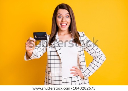 Photo portrait of excited business lady demonstrating bank plastic card isolated on bright yellow color background