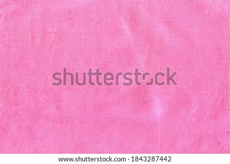 The texture of natural cotton fabric is pink. The background is a simple fabric, not very smooth, crumpled.