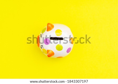 Piggybank on a yellow background. to save , saving money for affordable things, financial concept .Piggybank or deposit box on a wood background, depict saving money to make a trust fund for children