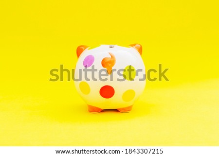 Piggybank on a yellow background. to save , saving money for affordable things, financial concept .Piggybank or deposit box on a wood background, depict saving money to make a trust fund for children