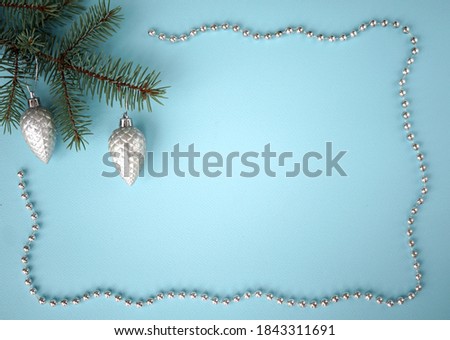       New year blue background with spruce twig and silver beads                       