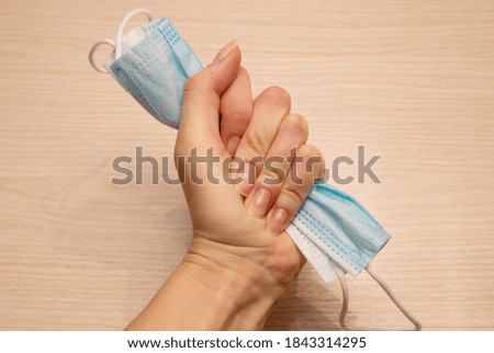 medical disposable mask for protection against carpet crumpled with force in the left female hand