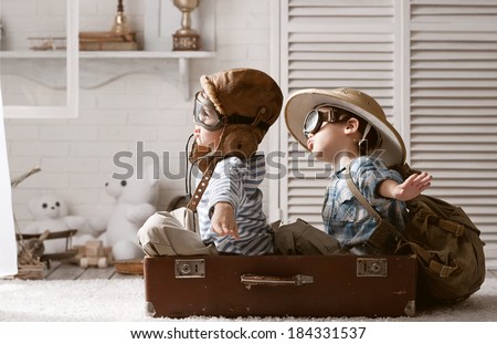 Two boys in the form of an aircraft pilot and traveler playing in her room Royalty-Free Stock Photo #184331537