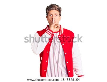 Young handsome man wearing baseball uniform asking to be quiet with finger on lips. silence and secret concept. 