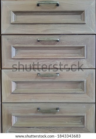 European style brass handles are attached to the wooden cabinet door.