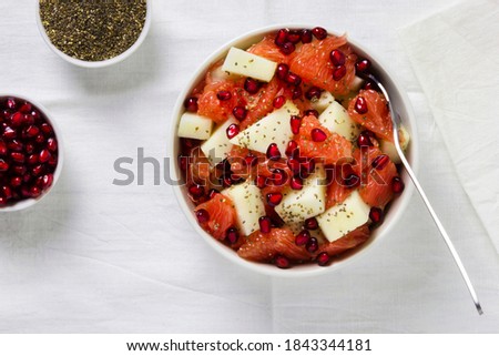 Fresh fruit salad in bowl on wooden table. Concept healthy food, diet, vegan. Flat lay, top view.