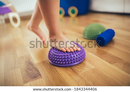 Flat feet correction exercise. Girl walking over spiked half balance massage balls
