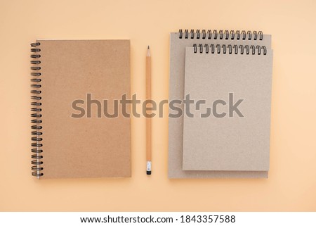 Top view above of Three school book brown closed spiral blank paper cover notebook with pencil isolated on blue background for design a mockup. Education and business concept. flat lay
