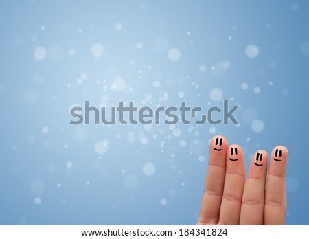 Happy finger smileys faces on hand with empty blue bokeh background