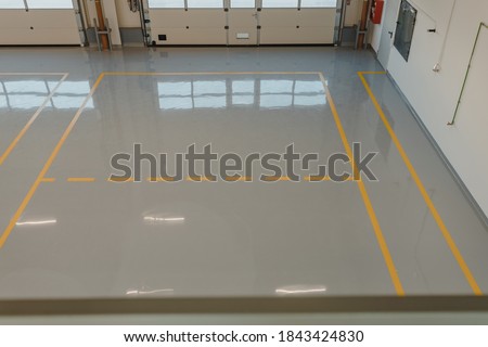 New  resin floor coating and marking signs in a car workshop. Royalty-Free Stock Photo #1843424830