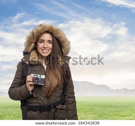beautiful young woman hiker taking a photo with the camera