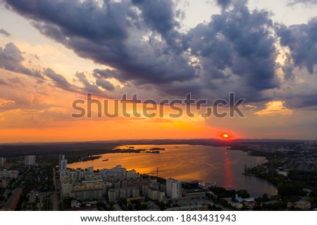 Aerial pink sunset sun and clouds over the evening metropolis in summer,