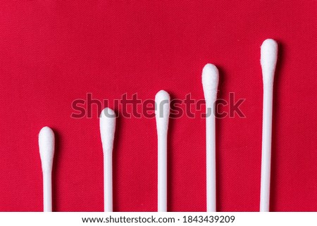 white swabs arranged on red background