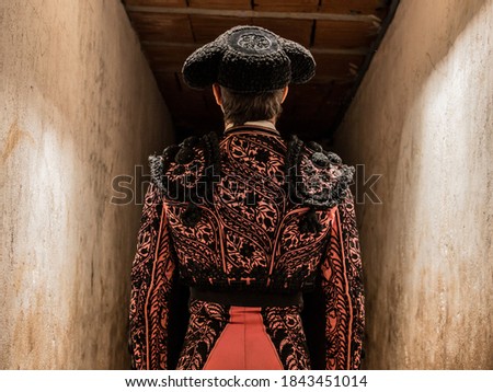 concentrated bullfighter waiting his turn in pink suit and cape. Royalty-Free Stock Photo #1843451014