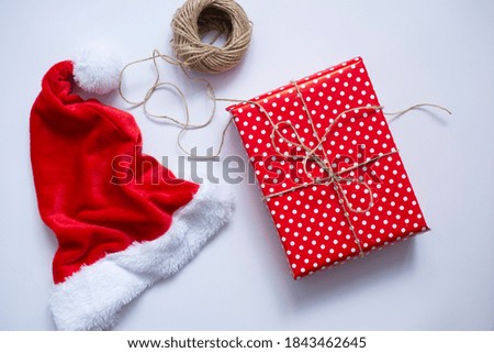 These are santas' cap and gift in red paper for Christmas on white background. Top view.