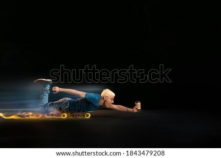 Speed. Fast delivery service - deliveryman on skateboard driving with order in fire on dark background. Copyspace for ad. Super fast shipping of food and goods orders during quarantine.