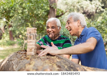 Men playing wooden blocks in park Royalty-Free Stock Photo #1843485493