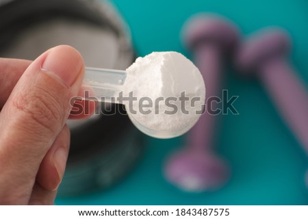 L-Glutamine supplement. Man holding a scoop of L-Glutamine powder in his hand. Close up. Royalty-Free Stock Photo #1843487575
