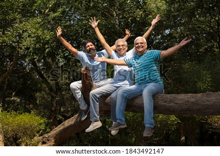 Three laughing senior friend relaxing at the park Royalty-Free Stock Photo #1843492147