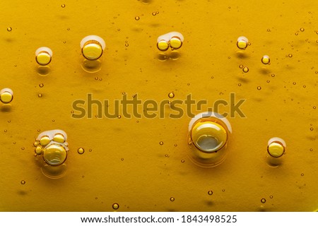 Yellow viscous liquid lecithin with bubbles on glass Royalty-Free Stock Photo #1843498525
