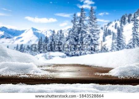 Table background with snow and winter landscape of mountains. 