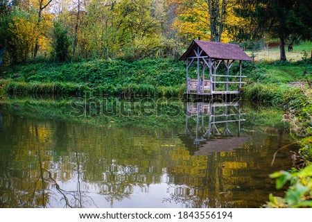 Picture of a little wooden boathouse at a natural lake on a beautiful, colourful autumnal day in October.