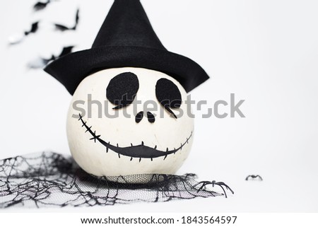 Studio portrait of white halloween smiling pumpkin with black hat. Isolated on white background.