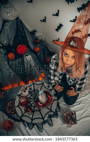 Beautiful young woman in witches hat enjoying party. Happy Halloween.