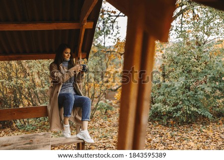 
girl with a camera in autumn park