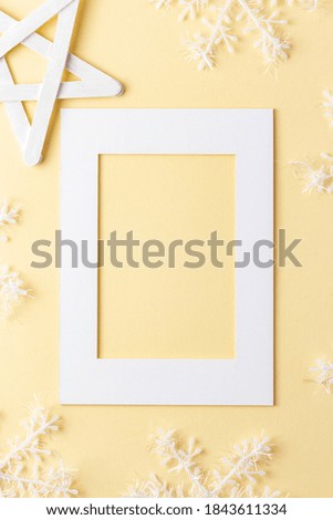Handmade Christmas greeting or invitation card composition made of paper frame and decorative snowflakes. New Year postcard or scrapbook mockup.