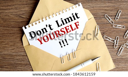dont limit yourself, text on white paper on craft envelope on the photo of the nineteen table