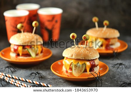 Funny monster burgers with chicken, tomato, cucumber, toast cheese and olive eyes. Food for Halloween.