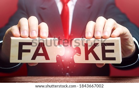 A man breaks a fake puzzle. Exposing fake news and false info. Debunking myths. Investigation of doubtful facts, information hygiene. Timely refutation. Stop influencing public opinion Royalty-Free Stock Photo #1843667002