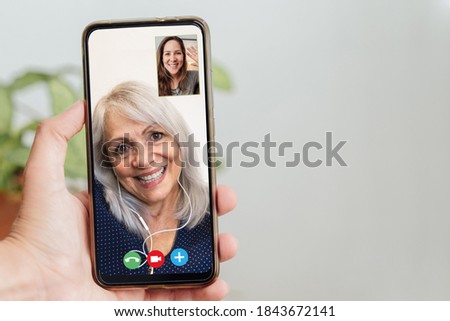Happy senior and daughter talking on video call with mobile phone during coronavirus outbreak - Online app and social distancing concept Royalty-Free Stock Photo #1843672141