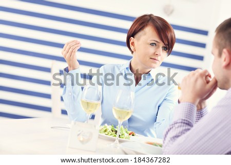 A picture of a young couple having an argument in a restaurant