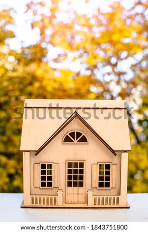 House symbol on a background of yellow autumn leaves