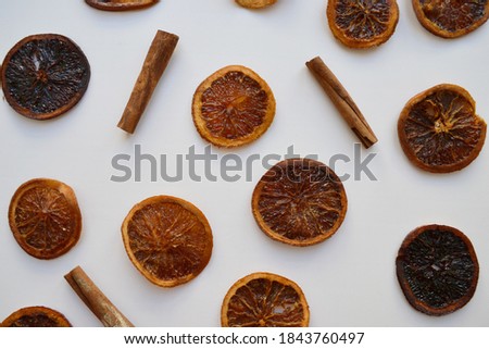 Dry oranges and cinnamon on a white background.
Dried slices of orange in sugar syrup. Spice.