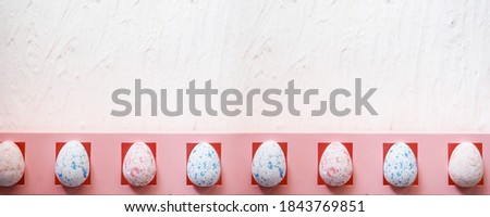 banner easter, holidays and tradition concept - row of colored artificial eggs on pink.