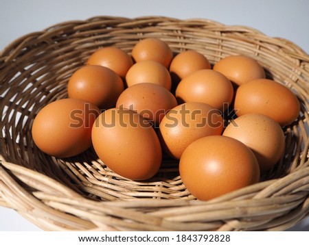 Several chicken eggs in a wooden tray