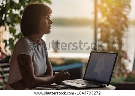 Young female copywriter working in modern office with laptop