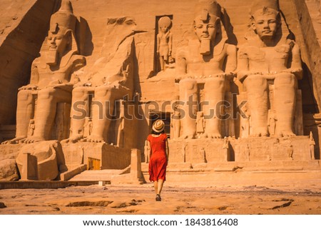 A young tourist in a red dress entering the Abu Simbel Temple in southern Egypt in Nubia next to Lake Nasser. Temple of Pharaoh Ramses II Royalty-Free Stock Photo #1843816408