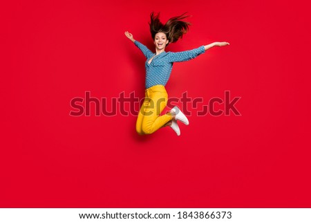Full length body size view of lovely careless glad cheerful girl jumping having fun isolated over bright red color background