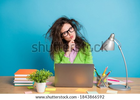 Photo of pensive girl sit table work laptop look copyspace think wear green shirt isolated over blue color background