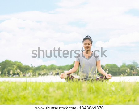 Asian women play yoga in the garden with a Lotus Pose pose.