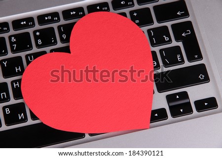 Red heart on computer keyboard close up